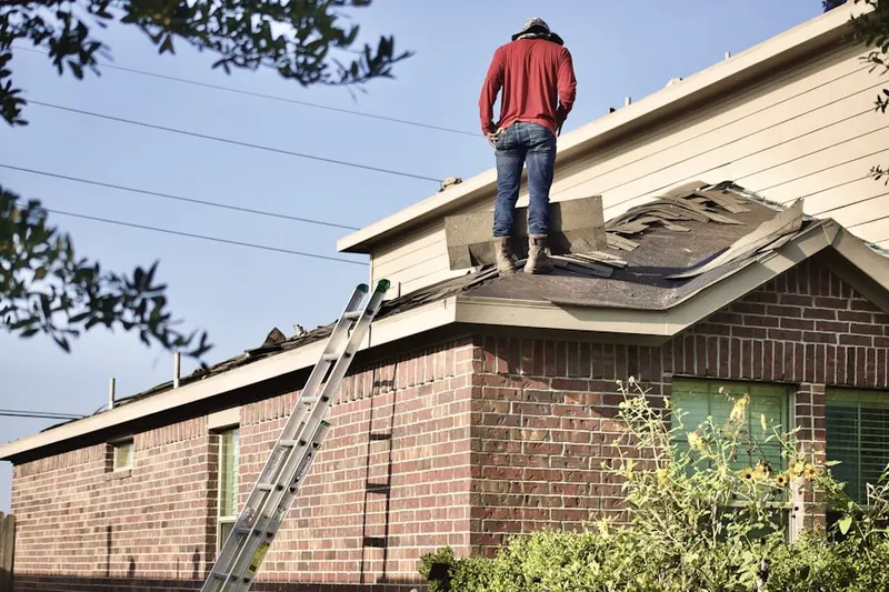 Professional roofer working on a residential roof in Coverts